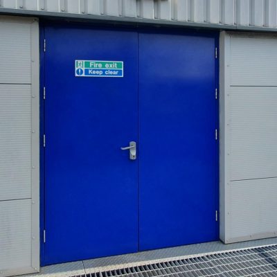 Blue double fire exit door fitted in an industrial building