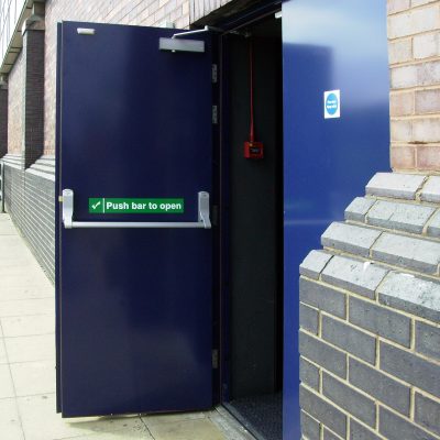 An open, dark blue fire exit door showing push bar and push bar to open sticker