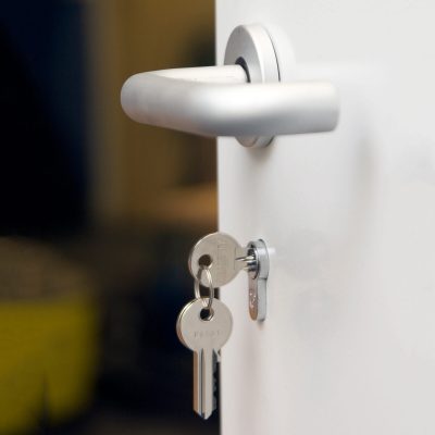 Close up of a key in the lock and a door handle
