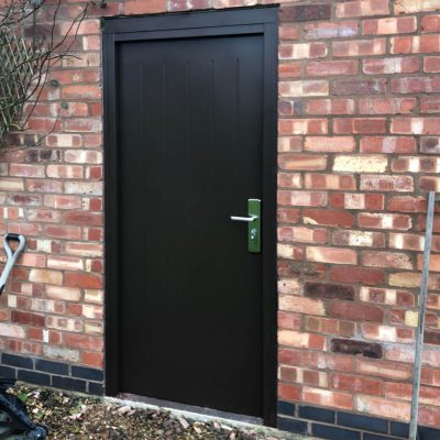 black cottage door fitted to out building