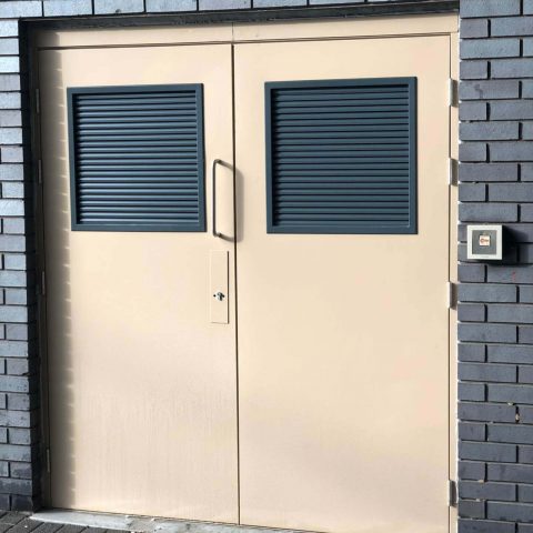 Beige security double door with grey louvres