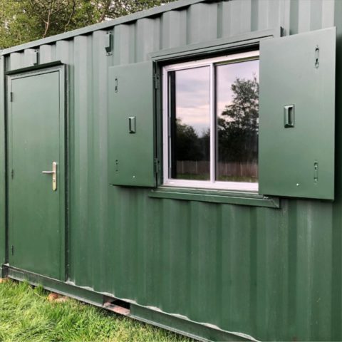 Green shipping container with shutter and door
