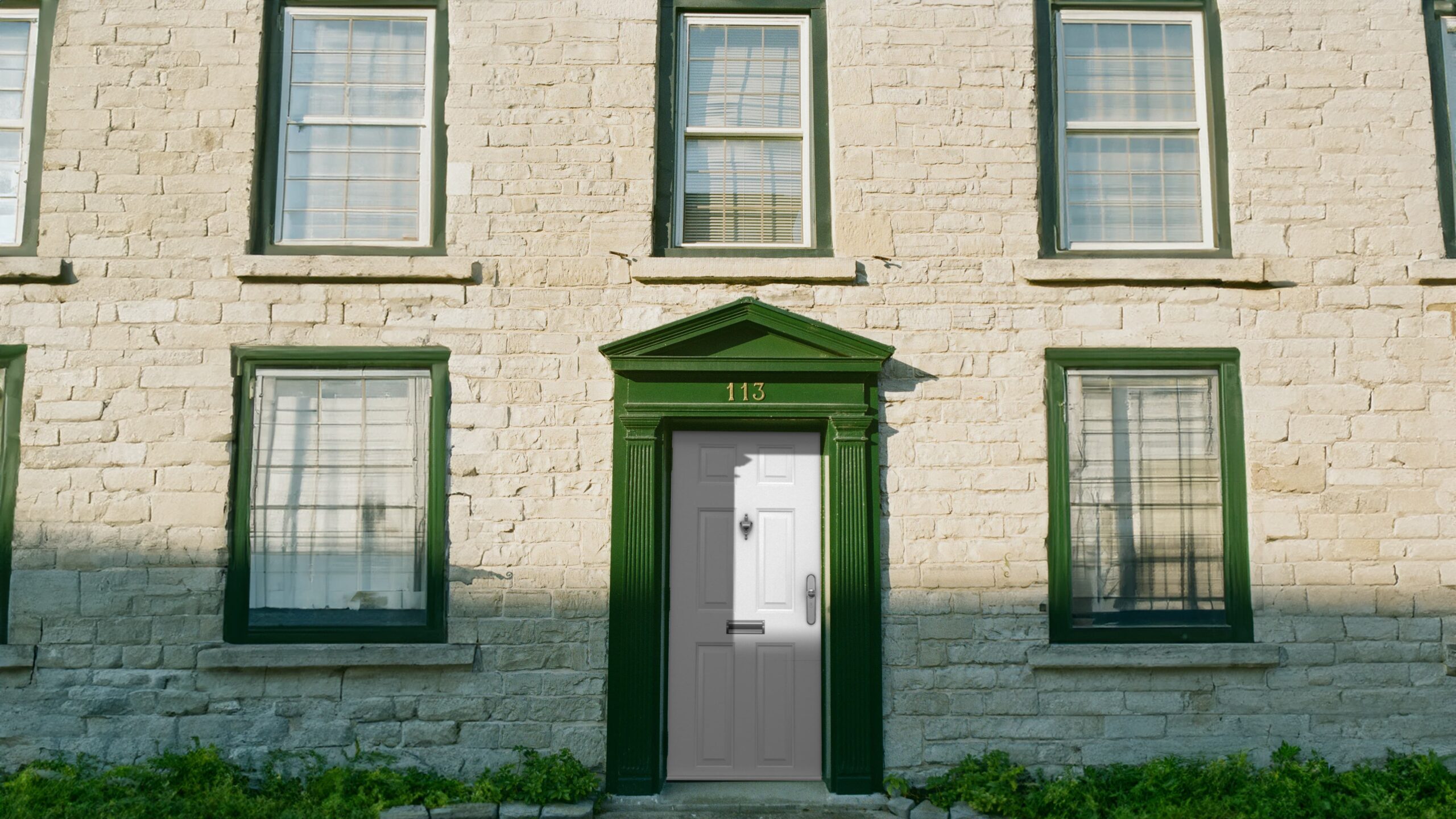 Green door on stone building facade.